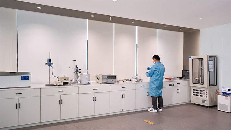 Laboratorio con apparecchiature di prova e un ingegnere al banco.