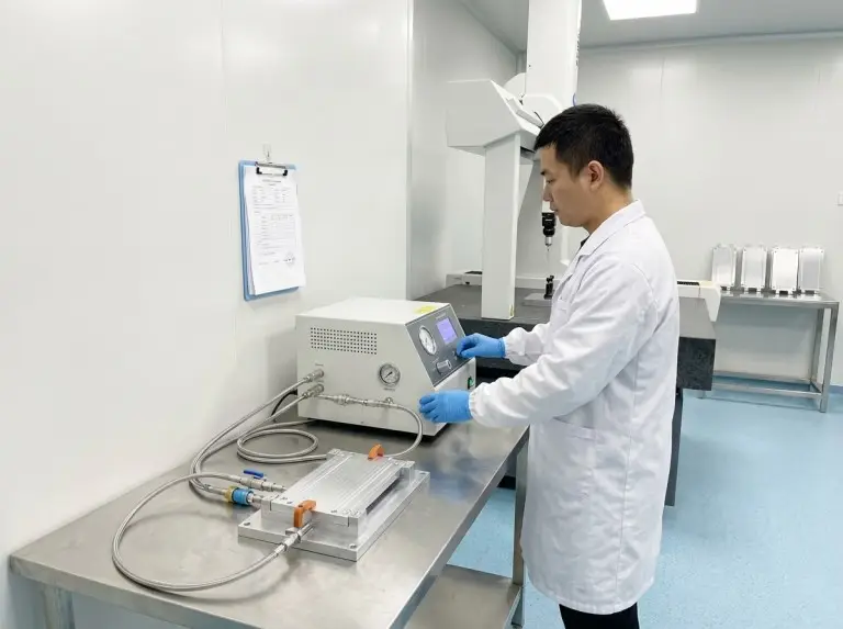 Technician testing a cold plate on a bench instrument in the test lab