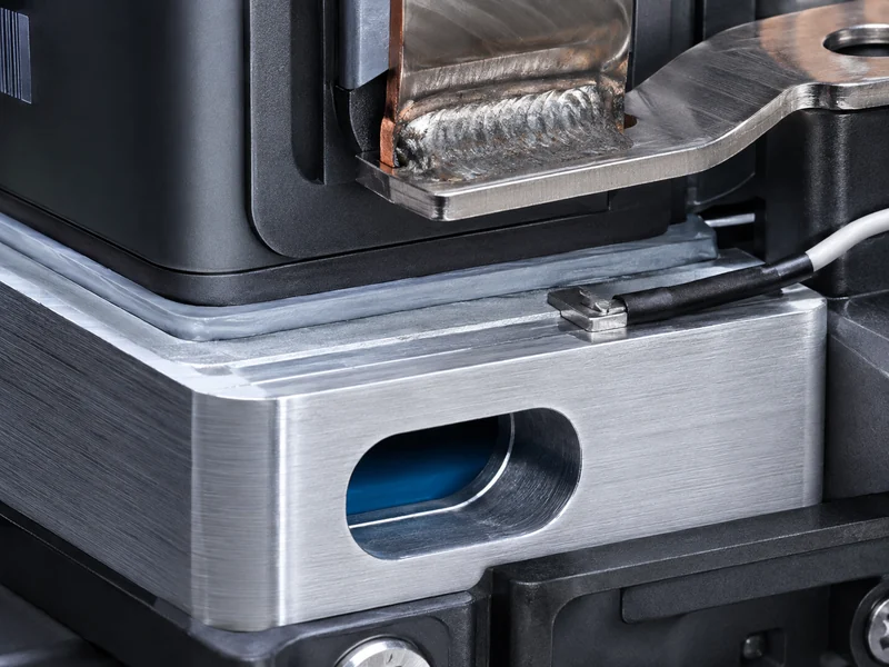 Close-up of battery module busbars and cold plate interface carrying the module heat load